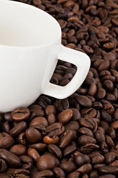 White coffee cup on the background of coffee beans.