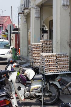 GEORGETOWN, PENANG, MALAYSIA - April 18, 2016: Lot of chicken egg packaged on a scooter waiting for customer near a small cafe. Fresh eggs ready for distribution.