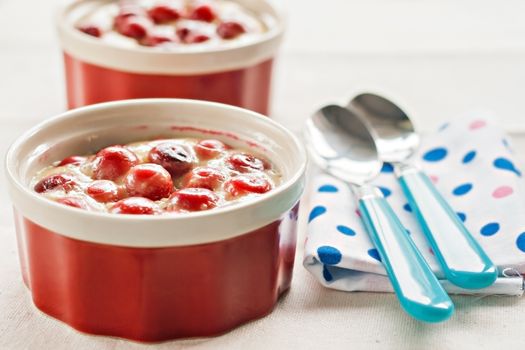 vanilla and cherry mousse, blue napkin and spoon in peas.