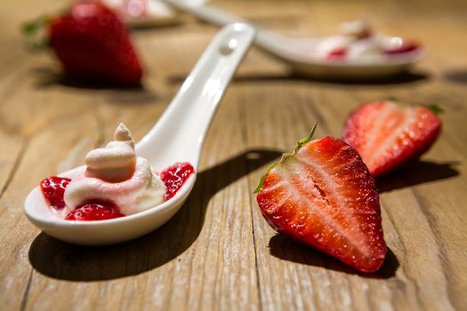Close up of a mascarpone cream and strawberries on wooden background