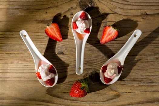 Mascarpone cream and strawberries seen from above on wooden background