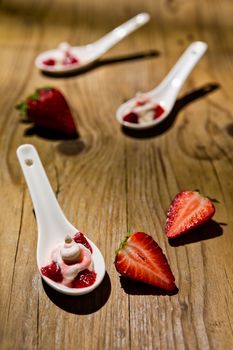 Mascarpone cream and strawberries on wooden background