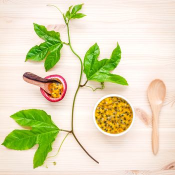 Fresh passion fruits set up on wooden background. Juicy passion fruits with green leaves  and Passion fruit vine flat lay .