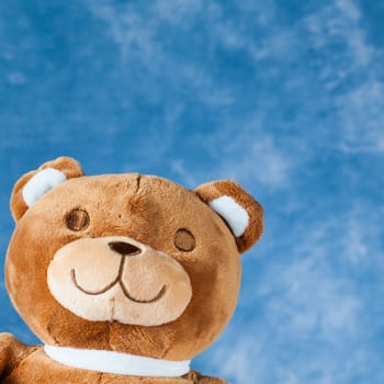 Teddy Bear toy on blue sky background with copyspace