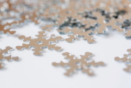 Christmas decoration of silver confetti snow flake against white background with nice boke. Close up confetti with shallow DOF