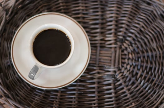 Cup of hot coffee on wicker baskets
