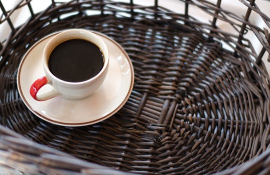 Cup of hot coffee on wicker baskets