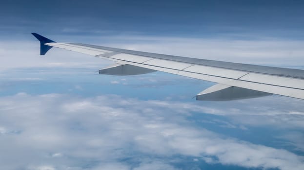 The airplane wing on the beautiful cloudy and sky.