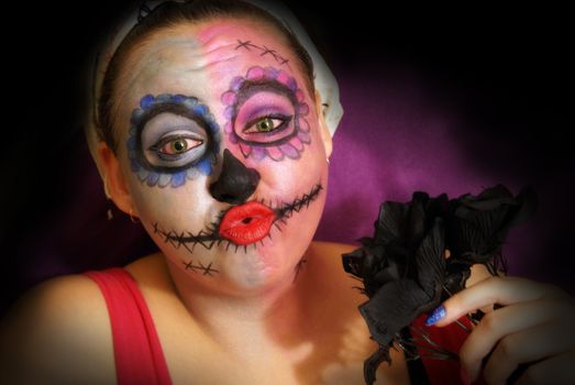 A woman in skull candy makeup for day of the dead celebrations.