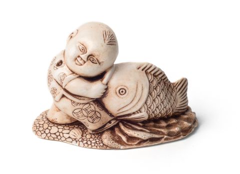 Netsuke of the boy with big fish. Isolated. A miniature sculpture, which was used as a button-like trinket in traditional Japanese clothes kimono kosode, which was devoid of pockets.