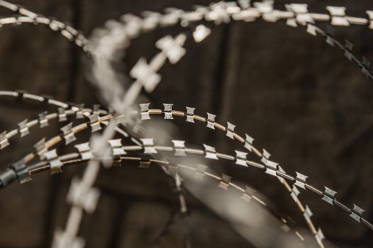 Close-up of a rusty metal razor fence wire outdoors.