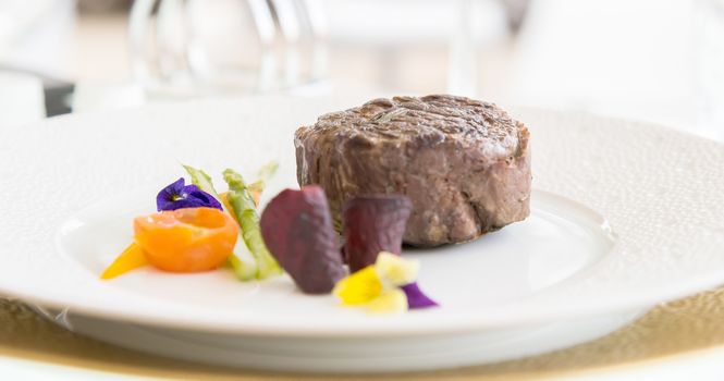 minimalistic dish steak with vegetables on a white plate