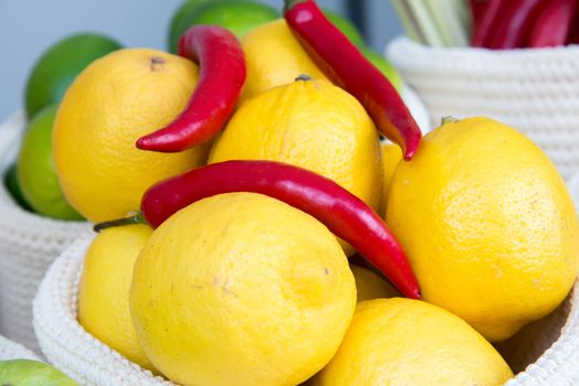 the lemons and chili peppers in a wicker basket close-up