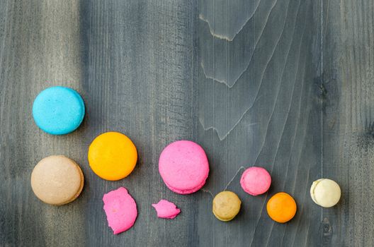 top view of colorful macaroons on a wooden background