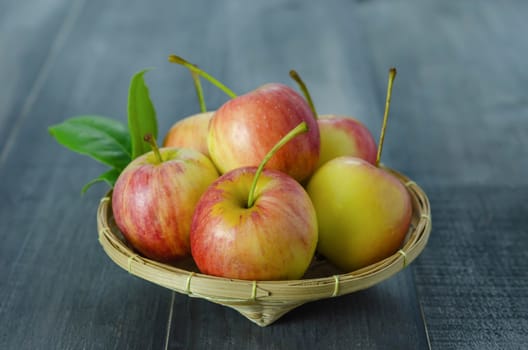 Red and yellow apple  with bamboo basket , organic fresh fruit on wooden background