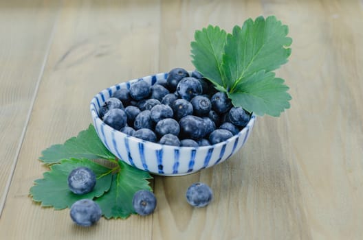 Blueberries in a bowl on a wooden background