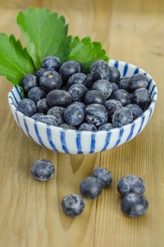 Blueberries in a bowl on a wooden background