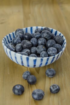 Blueberries in a bowl on a wooden background