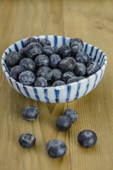 Blueberries in a bowl on a wooden background