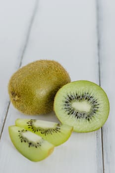 delicious whole kiwi fruit and sliced on wooden background