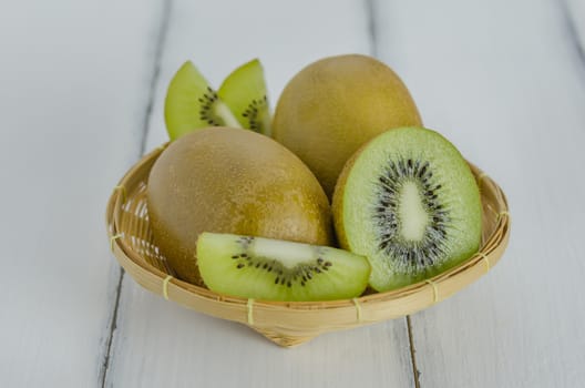 kiwi fruit and sliced with bamboo basket on wooden background
