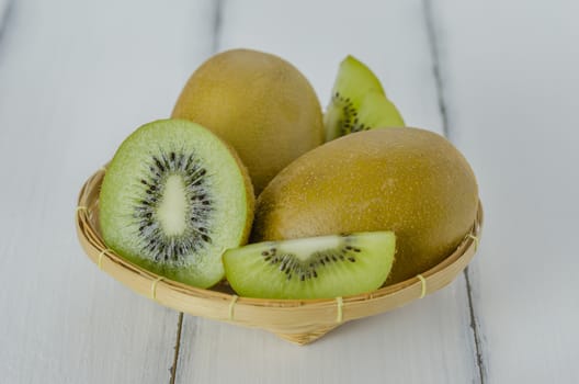 kiwi fruit and sliced with bamboo basket on wooden background