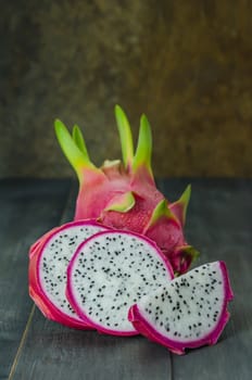 Ripe Dragon fruit or Pitaya with slice on wooden background , still life