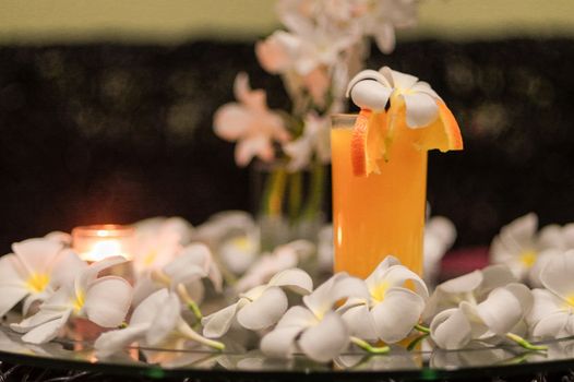 a freshly squeezed fresh orange juice, close-up with a Magnolia blossoms on the glas