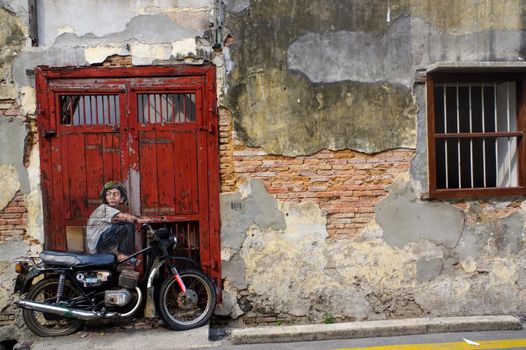 PENANG, MALAYSIA - April 18, 2016: A general view of a mural 'Boy on a Bike' painted by Ernest Zacharevic. The mural is one of the 9 murals paintings in early 2012.