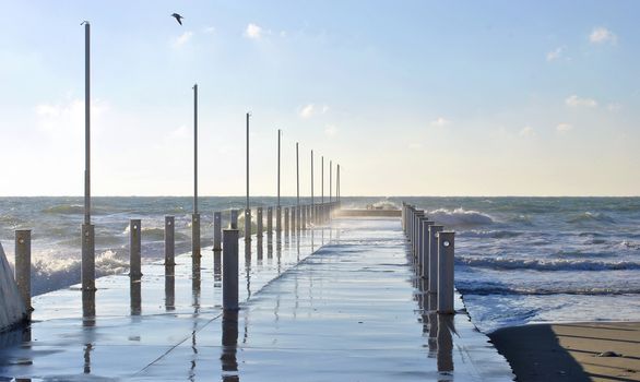 Sea wave splashing against a pier