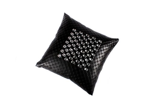 A luxurious black pillow made of leather and designed with glass beads, on white studio background