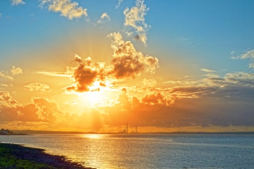 beautiful orange sunset over a power station on the river shannon in ireland