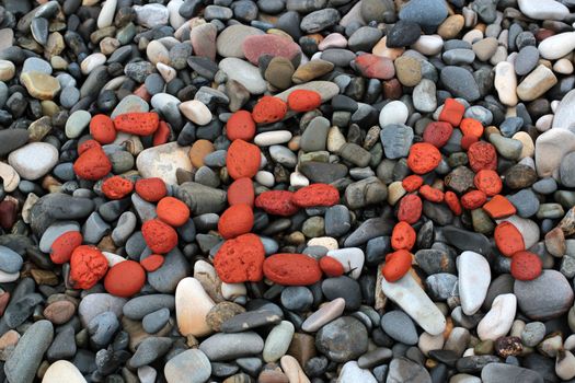 the word sea of red stones on a pebble beach