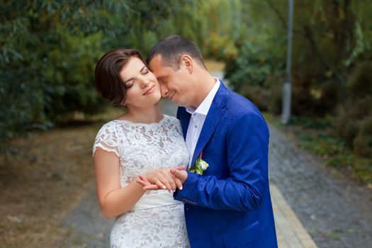 The groom gently hugged the bride standing in the rain