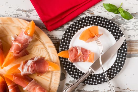 Italian prosciutto and melon on a plate seen from above