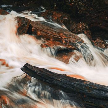 Knyvet Falls in Cradle Mountain, Tasmania after heavy rainfall with abstract red hues added.