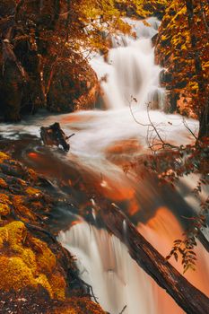 Knyvet Falls in Cradle Mountain, Tasmania after heavy rainfall with abstract red hues added.