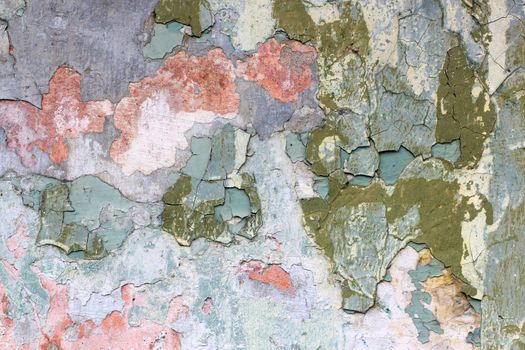 Tatter of a multi-colored old paint on a surface of a stone wall
