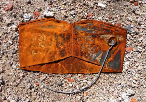 Old crushed rusty bucket on dusty background                               