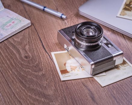 Vintage image with old Camera,old photo,laptop,pen and passport on wood table.