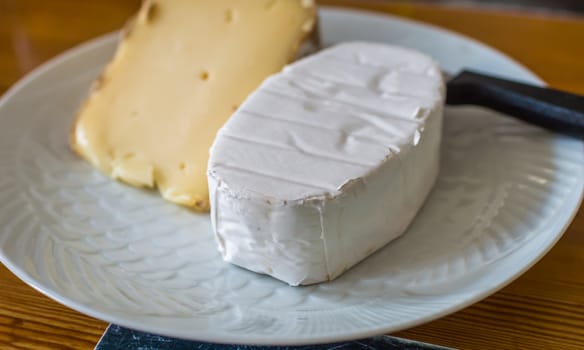 a piece of delicious French cheese in white plate on the table