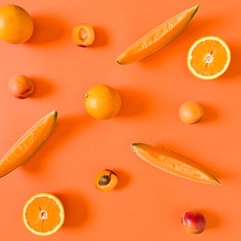 Fresh orange toned fruits over an orange background