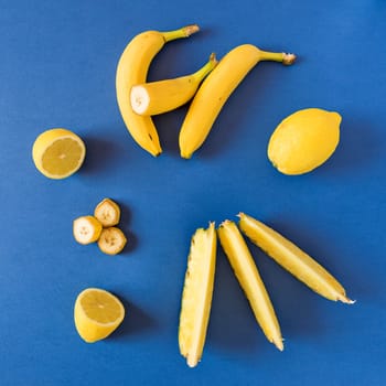 Fresh yellow toned fruits over a blue background