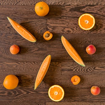 Fresh orange toned fruits over a wooden background
