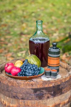 still life with oak barrel of fruit and red wine in the garden autumn