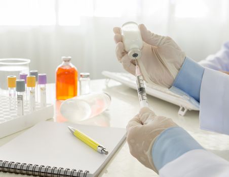 Doctor filling of a syringe with medicine from vial in hospital. healthcare and medical concept