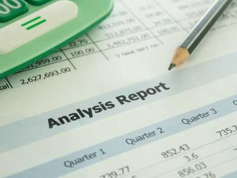 Marketer's desk with analysis Report ,Calculator, pencil.