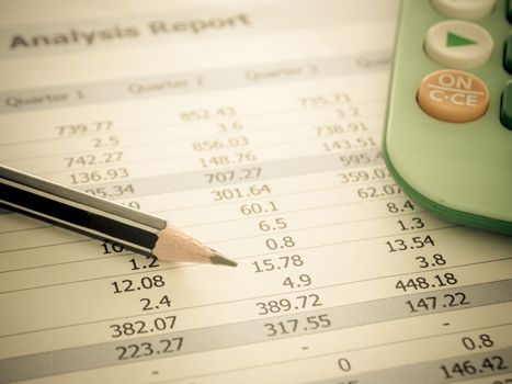 Marketer's desk with analysis Report ,Calculator, pencil.