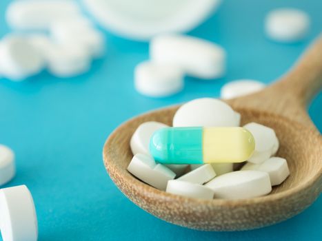 pills on wooden spoon. health concept. medical concept. selective focus