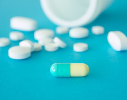 capsule pill on blue blackground, selective focus